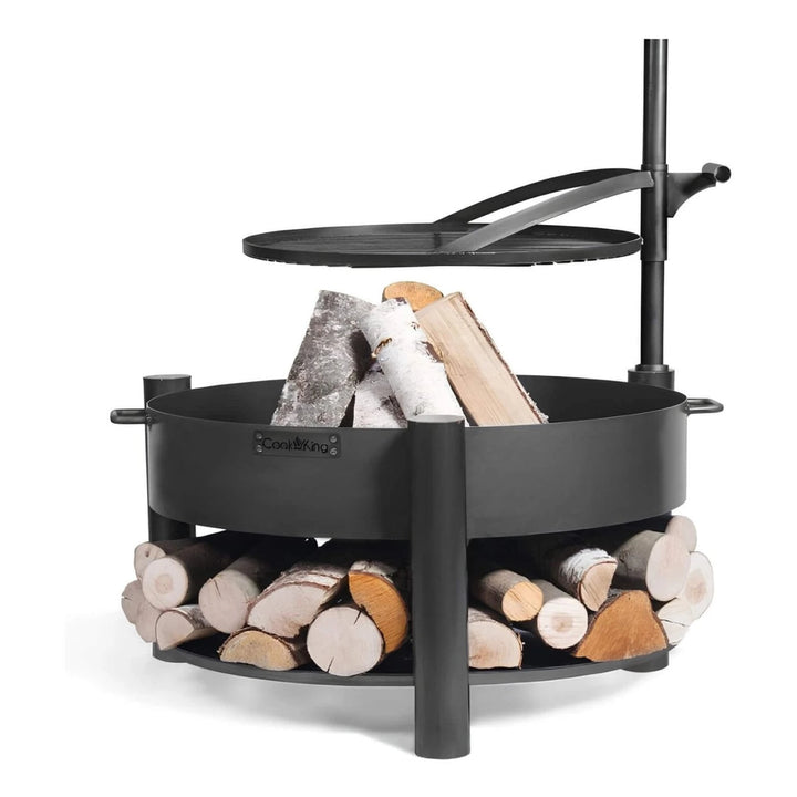 Multifunktionale Feuerschale MONTANA X + Grillrost – Feuerschale mit schwenkbarem Grillrost und gefüllter Holzablage