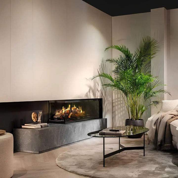 Elektrokamin Kalfire E-one 130C – Elektrokamin mit Eckverglasung neben Sofa und Zimmerpflanze