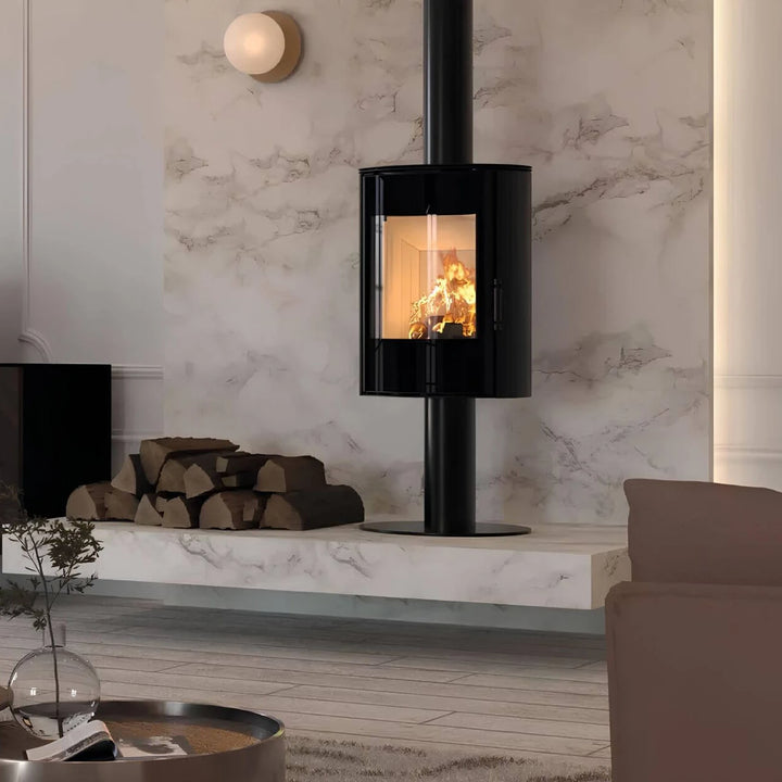 Kaminofen Hitze Ellisse SF 5,3 kW – Kaminofen auf Standfuß mit Feuer vor einer Steinwand