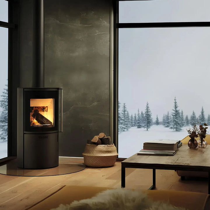 Kaminofen Varde Ovne Nordic 3 | 5 kW – Kaminofen mit Feuer vor einer Fensterfront mit Schneelandschaft