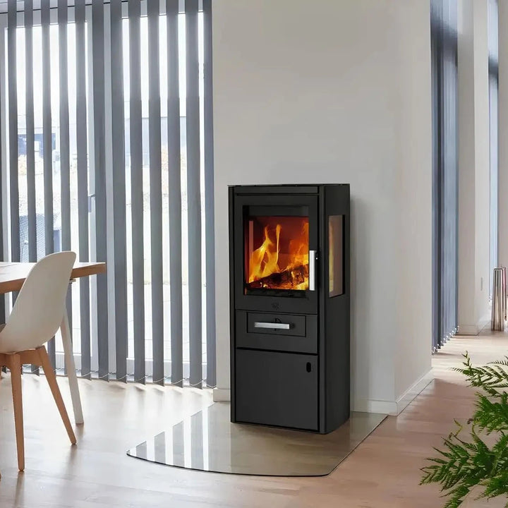 Kaminofen Varde Ovne Bornholm 5,5 kW – Kaminofen mit Feuer im hellen Wohnraum neben einem Esstisch