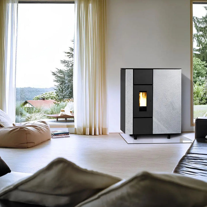 Pelletofen Wodtke ixbase air+ | 6 kW – Pelletofen mit heller Steinverkleidung auf einer Glasplatte im Wohnraum