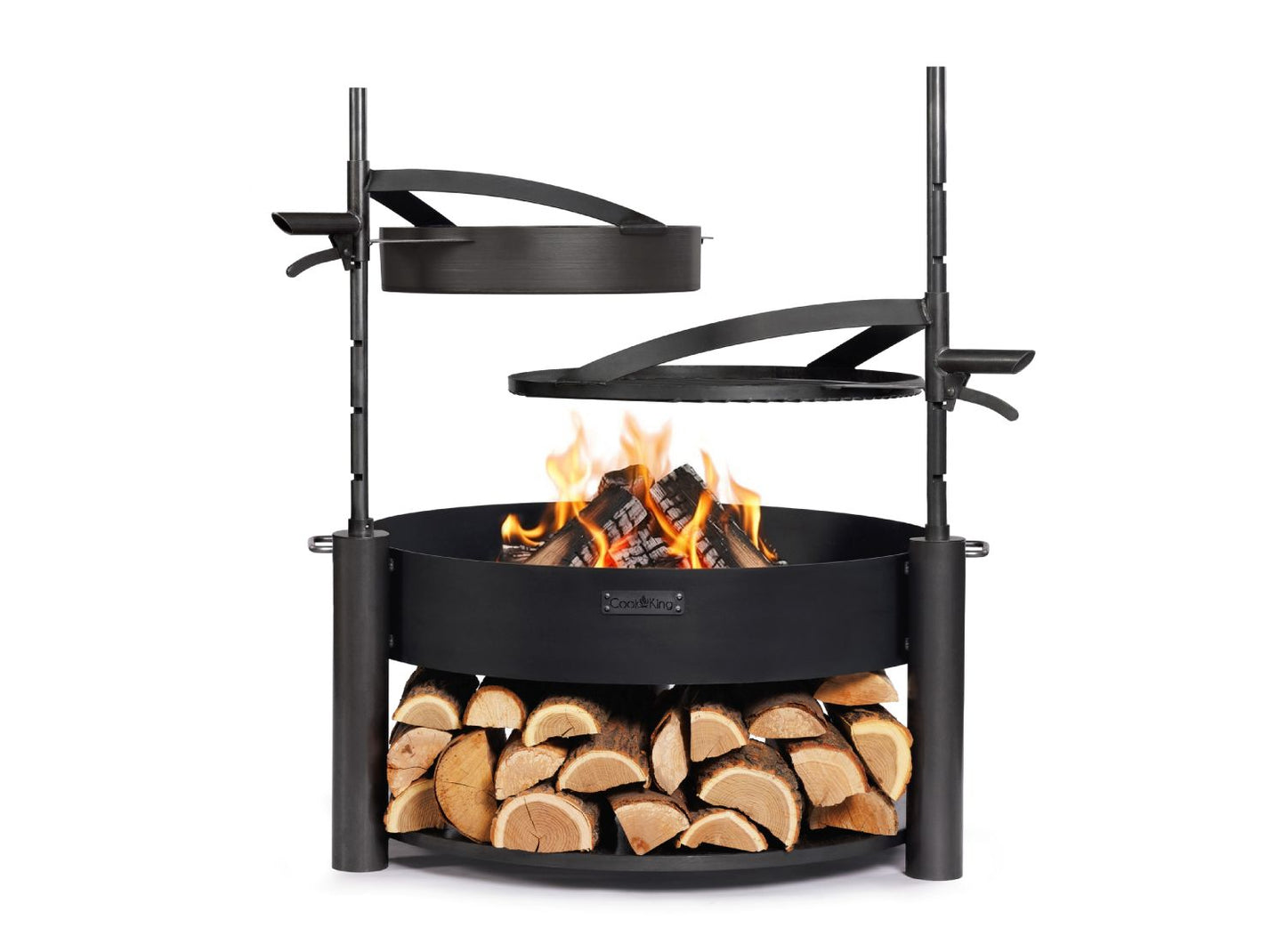 Feuerschale MONTANA X 80 cm mit brennendem Holz, höhenverstellbarem Grillrost und Stahlpfanne sowie Holzlagerung im unteren Bereich