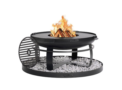 Massive Viking Feuerschale 80cm aus Naturstahl mit brennendem Holzfeuer, aufgelegter Grillplatte und runder Steinbasis zum Schutz der Terrasse.