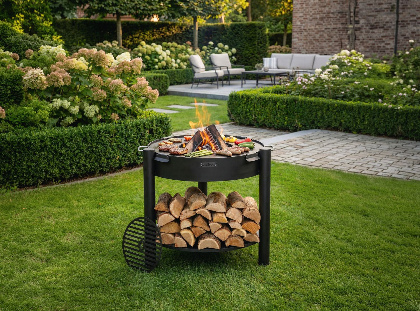 Feuerschale CookKing Montana hoch 80 cm mit Grillplatte 78 cm und Grillrost 37 cm im Garten, Naturstahl Feuerstelle mit Holzablage und Grillfunktion in Nutzung