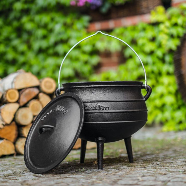 Afrikanischer Gusseisenkessel – Geöffneter Kessel mit angelehntem Deckel im Garten