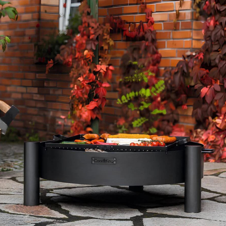 Feuerschale CookKing Haiti – Feuerschale mit Grillgut vor Backsteinwand
