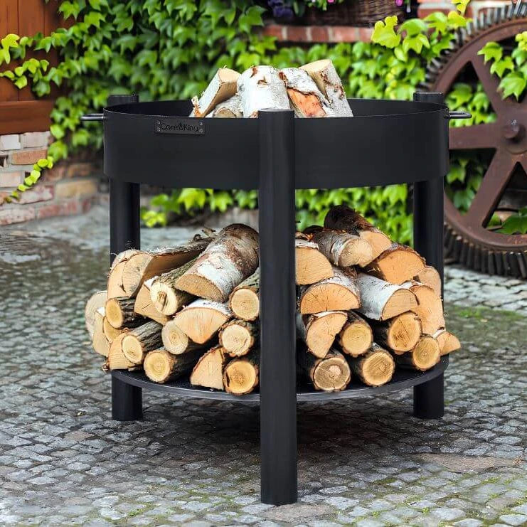 Feuerschale CookKing Montana hoch – Feuerschale mit Holzscheiten und gefüllter Holzablage im Garten