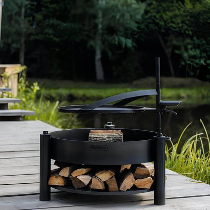 Multifunktionale Feuerschale MONTANA X + Grillrost – Feuerschale mit schwenkbarem Grillrost und Holzablage auf einer Terrasse