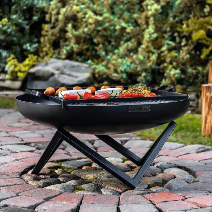 Feuerschale CookKing Santiago – Feuerschale mit Grillgut auf Gartenpflaster