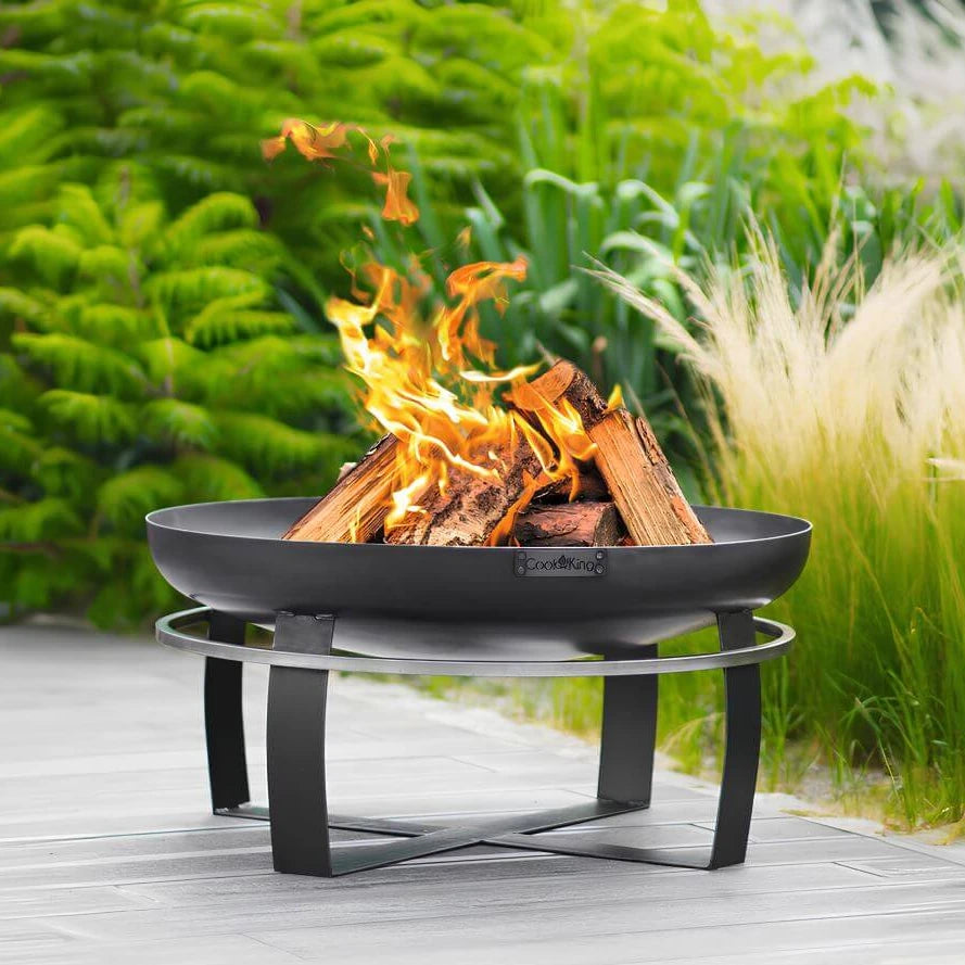 Feuerschale CookKing Viking – Feuerschale mit Feuer auf einer Holzterrasse im Garten