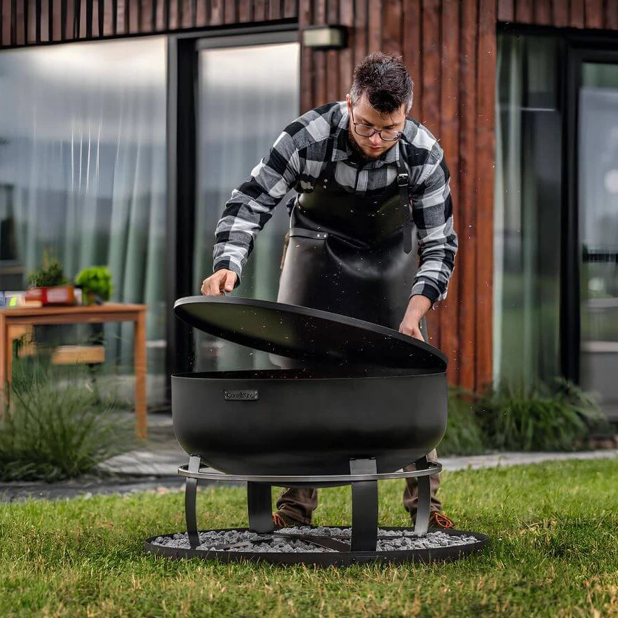 Feuerschale CookKing XXL Viking – Mann beim Auflegen des Deckels auf die Feuerschale im Garten