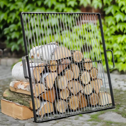 Quadratischer CookKing Grillrost aus Naturstahl an Holzscheiten vor grünen Pflanzen