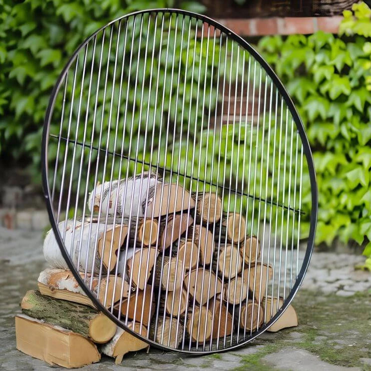 Runder Grillrost aus Naturstahl – Runder Grillrost an Holzscheiten angelehnt im Garten