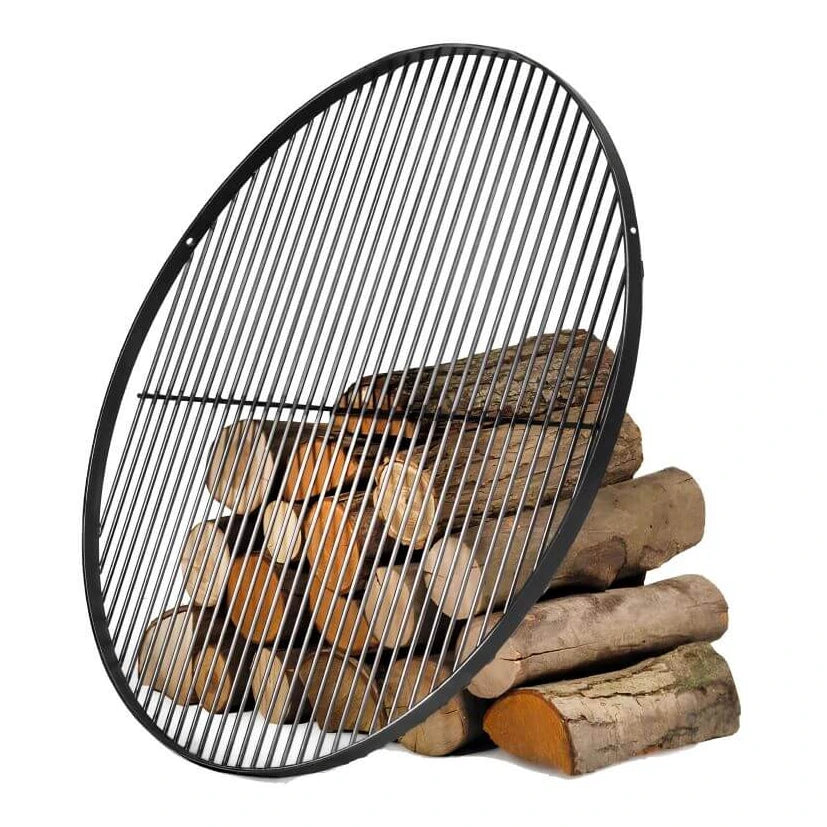 Runder Grillrost aus Naturstahl – Runder Grillrost an Holzscheiten angelehnt auf weißem Hintergrund