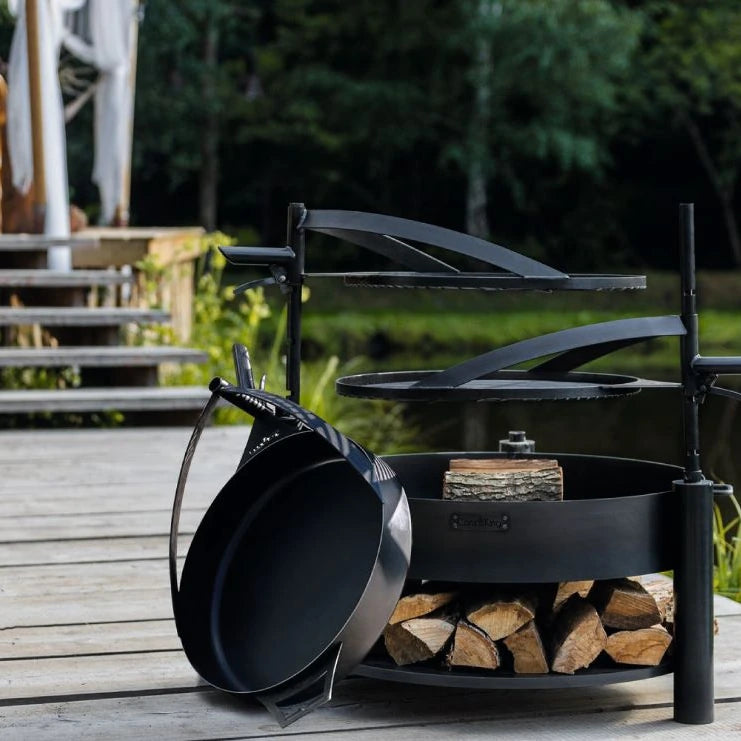 Pfanne aus Naturstahl mit Griff – Pfanne und Grillaufsätze an einer Feuerschale auf einer Terrasse