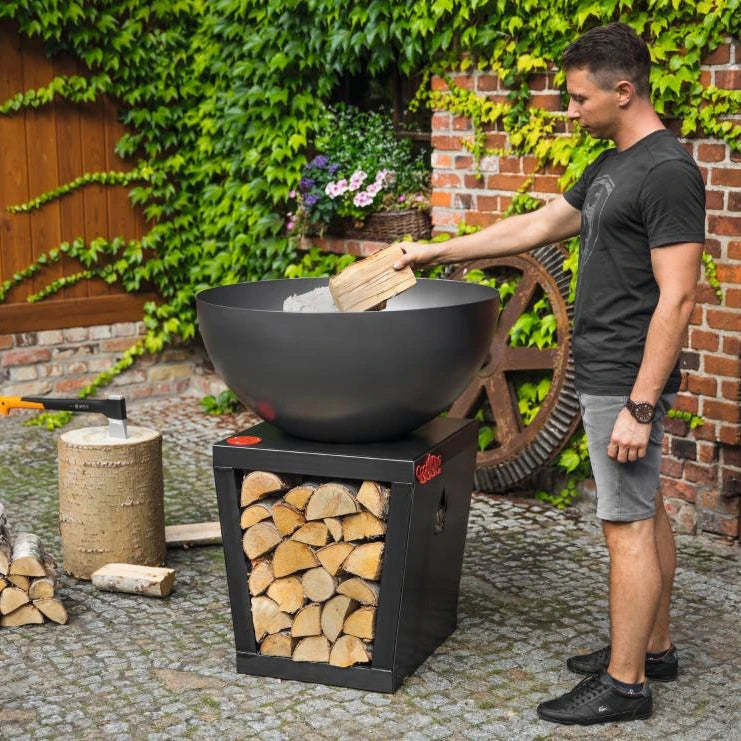 Cookking Premium Grill Santos – Befüllen der Grillschale mit Holz im Garten