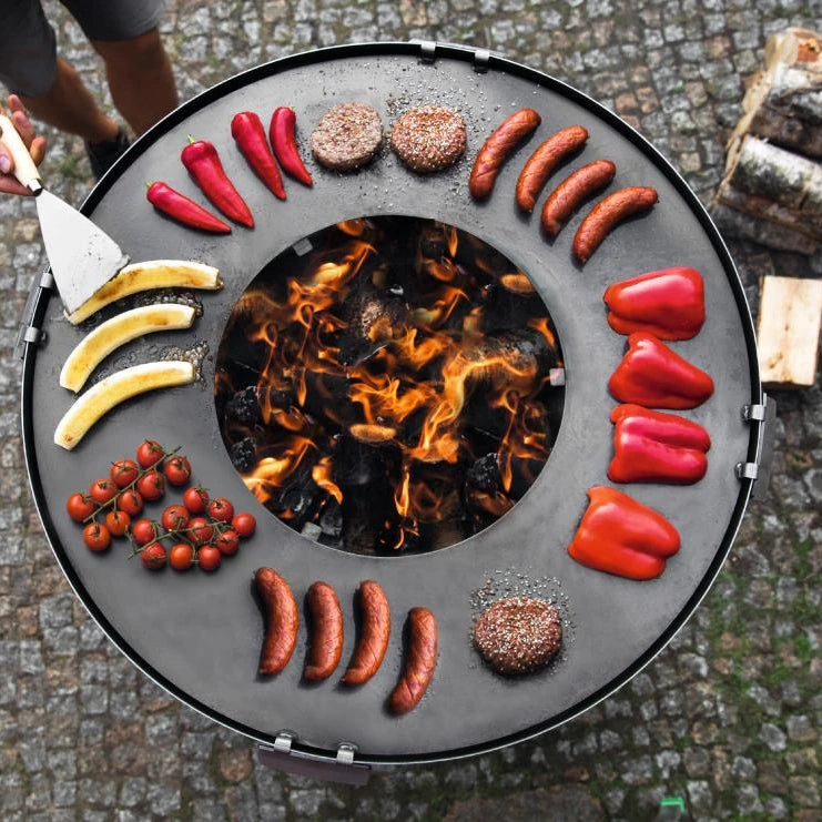 Cookking Premium Grill Santos – Draufsicht auf die runde Grillplatte mit Grillgut und Feueröffnung