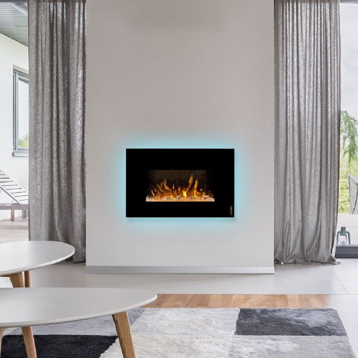 Elektrokamin Wodtke feel the flame iVision – im Wohnraum mit blauem Lichtschein hinter dem Rahmen