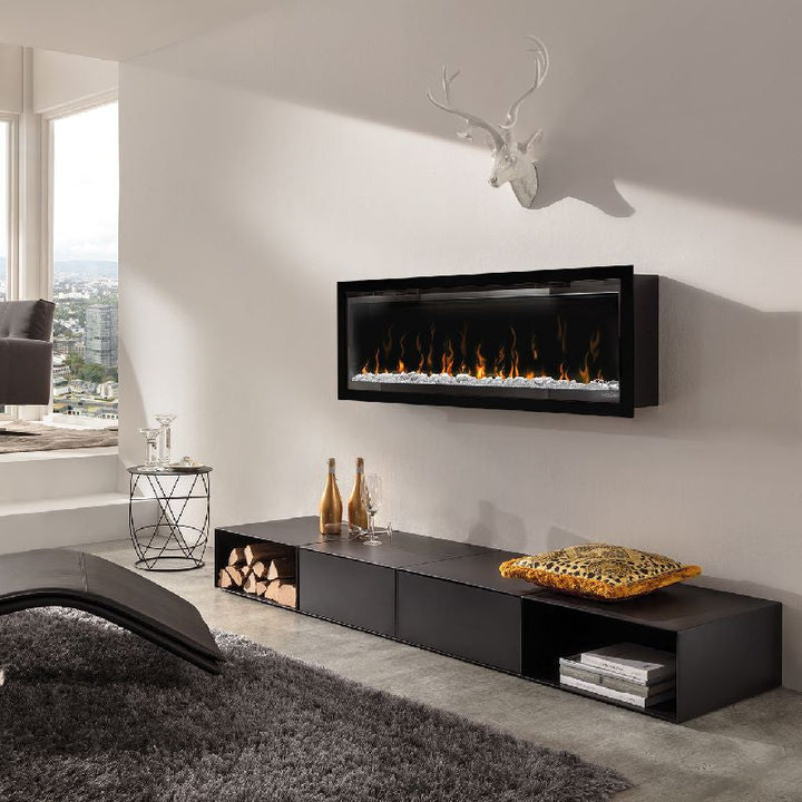 Elektrokamin Wodtke feel the flame X – Schwarzer Wandkamin über einem niedrigen Regal im Wohnraum