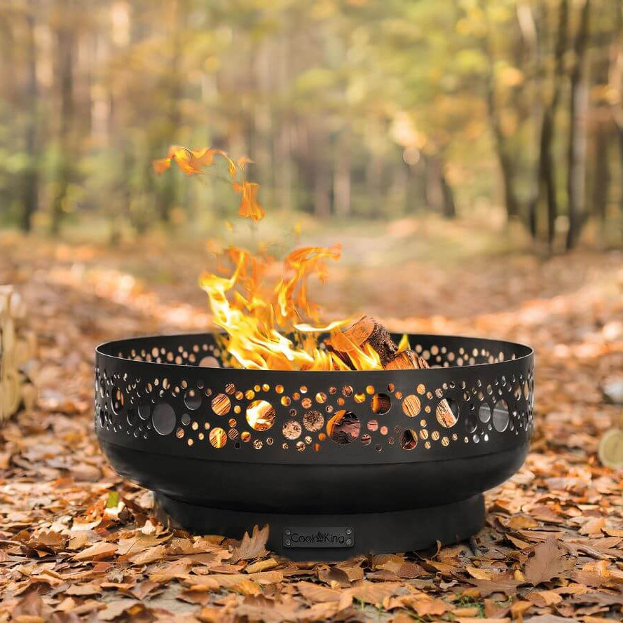 Feuerschale CookKing Boston 80 cm – Feuerschale mit Lochmuster und brennendem Holz auf herbstlichem Laub