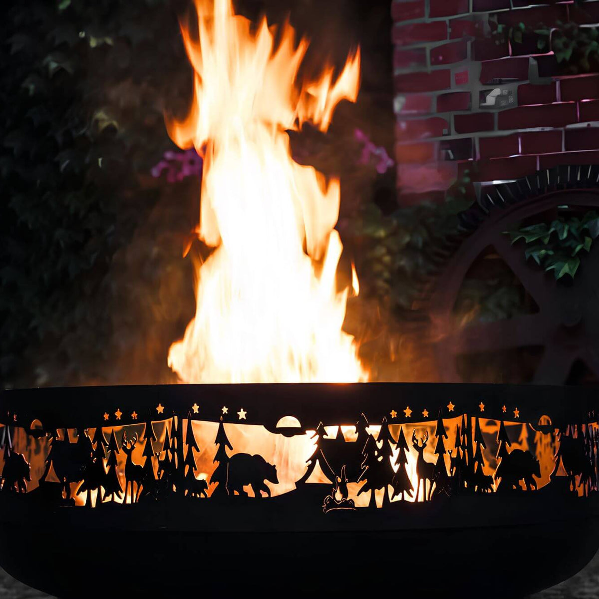 Feuerschale CookKing Forest 80 cm – Detail von Flammen und beleuchteten Waldmotiven in der Schalenwand