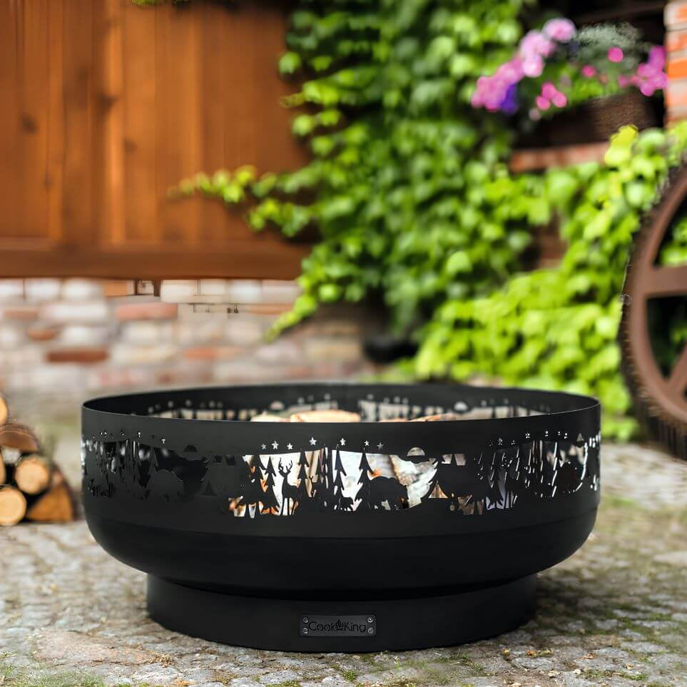 Feuerschale CookKing Forest 80 cm – Feuerschale mit Holzscheiten auf Gartenpflaster