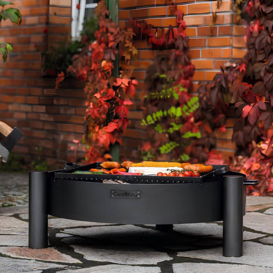Feuerschale CookKing Haiti – Feuerschale mit Grillgut vor Backsteinwand