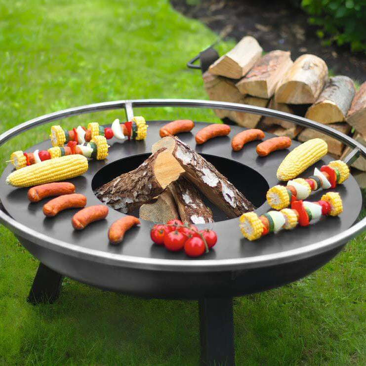 Feuerschale CookKing Porto – Detail der aufgelegten Grillplatte mit Grillgut und Holzscheiten