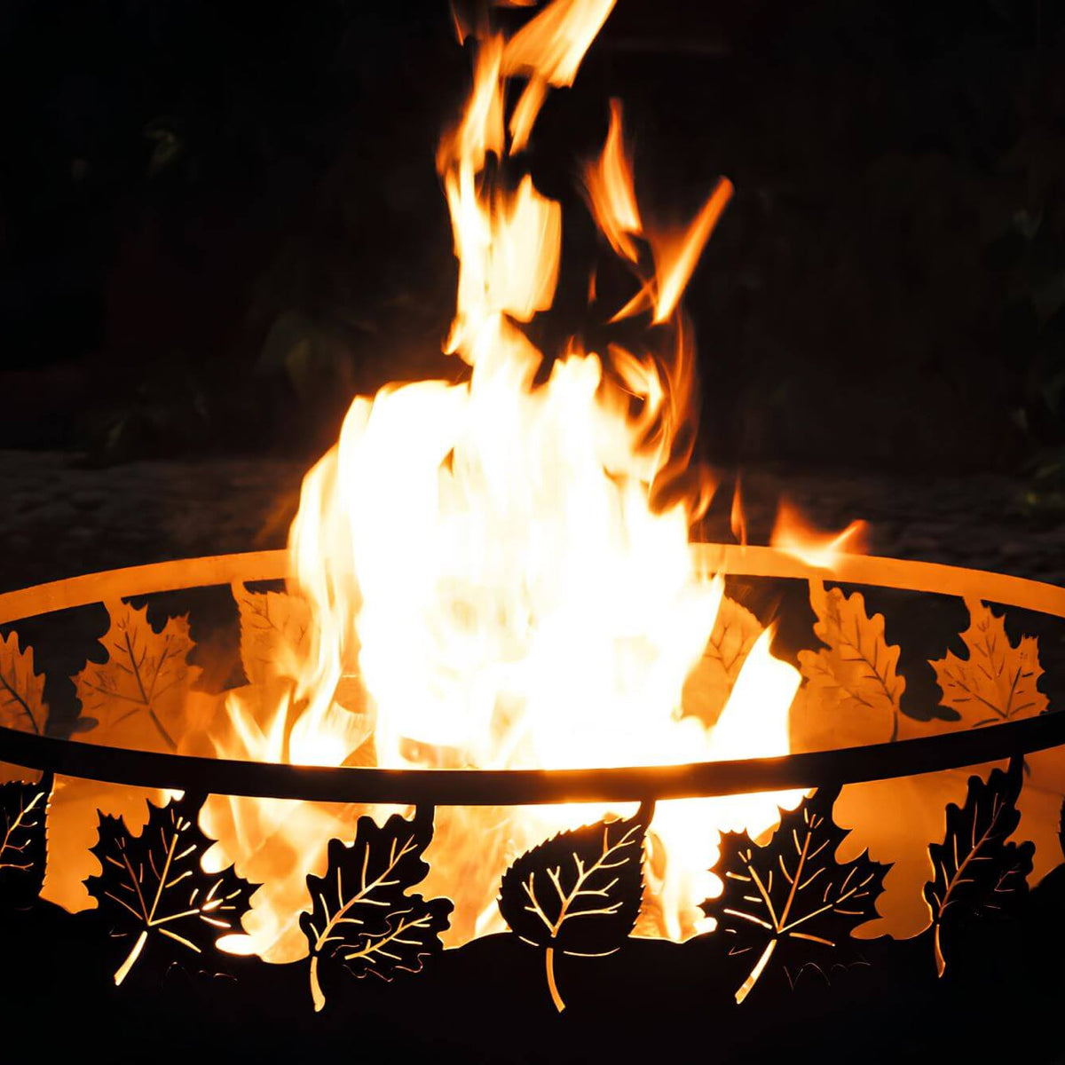Feuerschale CookKing Toronto 80 cm – Detail von Flammen und beleuchtetem Blättermuster in der Schalenwand