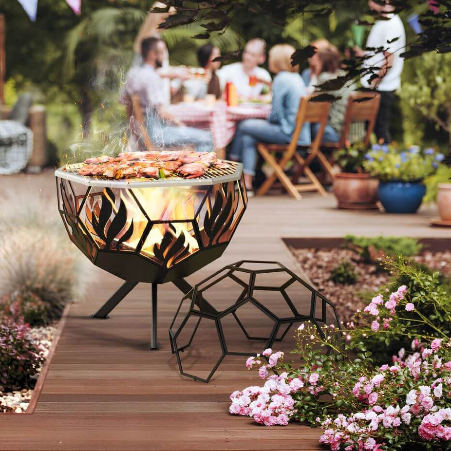 Gartenfeuerstelle Hitze Hogar – Gartenfeuerstelle mit Grillgut und abgenommener Gitterhaube auf einer Terrasse
