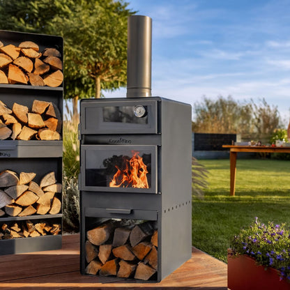 Gartenofen Vento mit Backofen + Rohstahlrost und Holzregal 120×40×30 cm – Brennender Gartenofen auf einer Holzterrasse