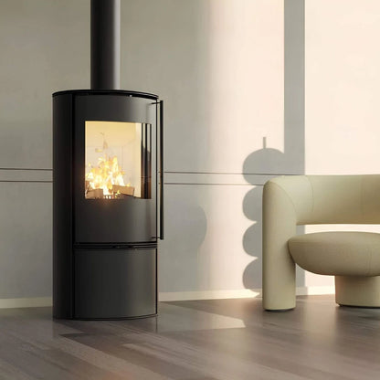 Kaminofen Hitze Bane 5 kW – Kaminofen mit Feuer neben einem hellen Sessel