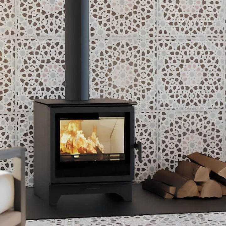 Kaminofen Hitze Gatto M 5,3 kW – Kaminofen mit Feuer vor einer gemusterten Wand