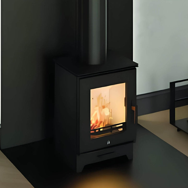 Kaminofen Hitze Gatto SE 5,3 kW – Kaminofen mit Feuer und Rauchrohr vor einer dunklen Wand