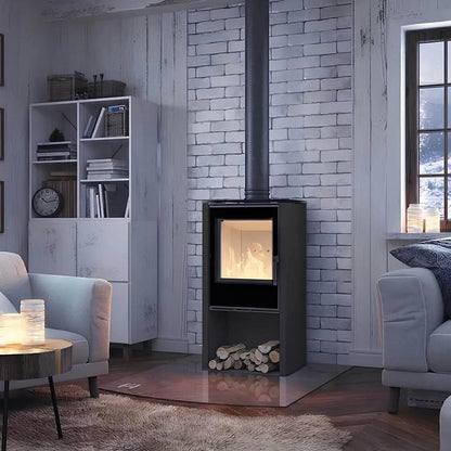Kaminofen Hitze Lupo S 6,5 kW – Dunkler Kaminofen mit Feuer und Holzfach vor einer hellen Ziegelwand