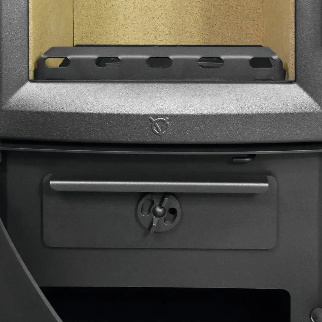 Kaminofen Varde Ovne Aura 3 Naturstein 5 kW – Geöffneter unterer Brennraumbereich mit Rost und Bedienelementen