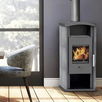 Kaminofen Wamsler Gron | 6 kW – Kaminofen mit Feuer und Rauchrohr neben einem Sessel