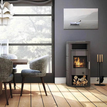 Dauerbrandofen Wamsler Thyra DB mit Automatik | 6 kW – Kaminofen neben einer Sitzgruppe am großen Fenster