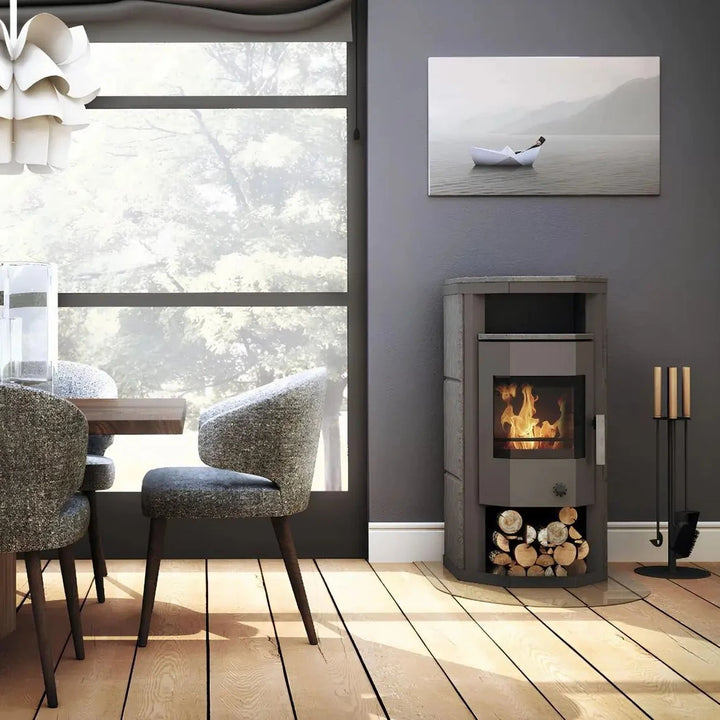Dauerbrandofen Wamsler Thyra DB mit Automatik | 6 kW – Kaminofen neben einer Sitzgruppe am großen Fenster