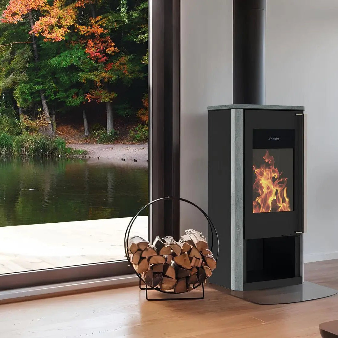 Kaminofen Wamsler Turon Naturstein | 8 kW – Kaminofen mit Rauchrohr neben einem Fenster mit Seeblick