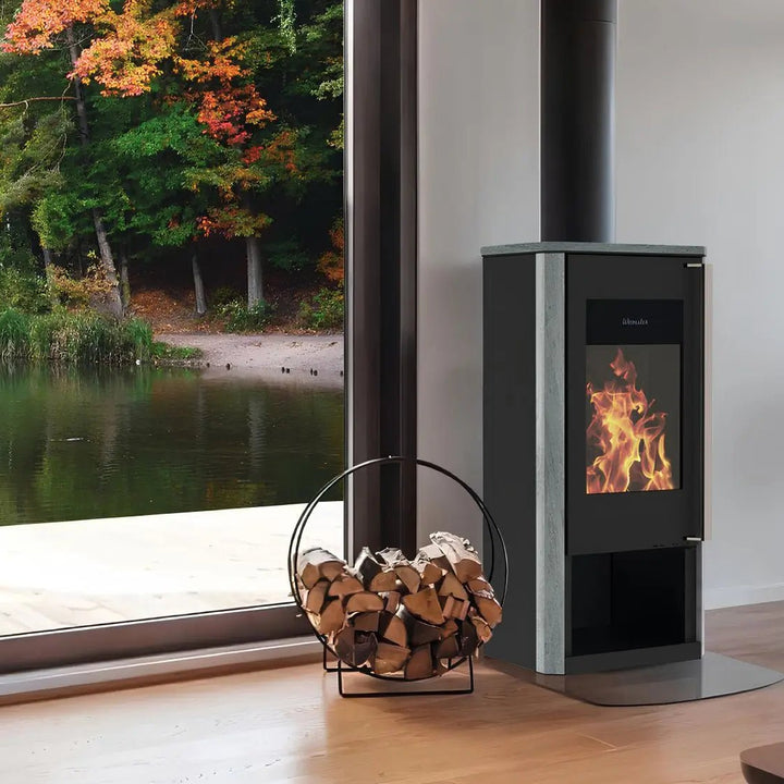 Kaminofen Wamsler Turon Naturstein | 8 kW – Kaminofen mit Rauchrohr neben einem Fenster mit Seeblick