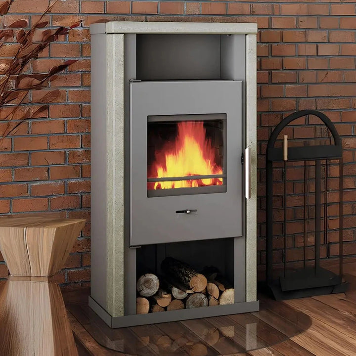 Kaminofen Wamsler Yuna Naturstein | 6 kW – Kaminofen mit Feuer und Holzfach vor einer Ziegelwand