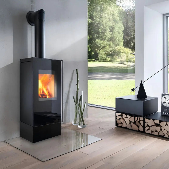 Kaminofen Wodtke Casa duo | 6 kW – Kaminofen mit Glasfront und Rauchrohr neben einem großen Fenster