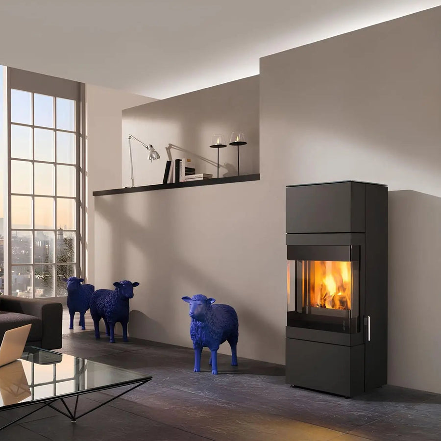 Kaminofen Wodtke Stage F9 | 6 kW – Kaminofen mit Feuer im Wohnraum mit blauen Schafskulpturen