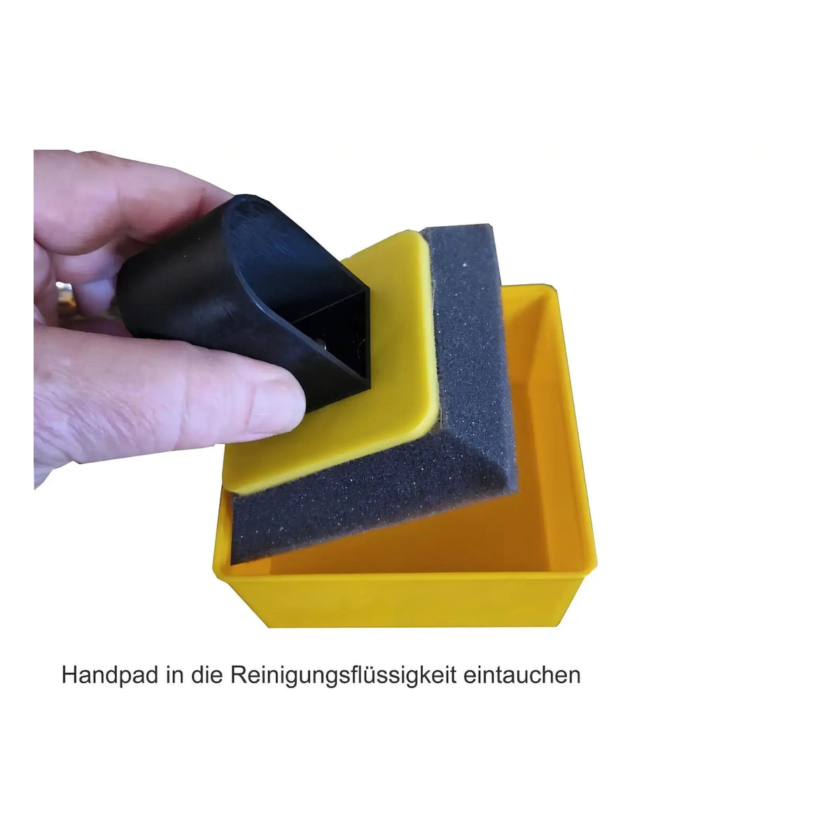Kaminscheiben Präsent-BOX kompakt – Handwischer wird in eine gelbe Schale eingetaucht
