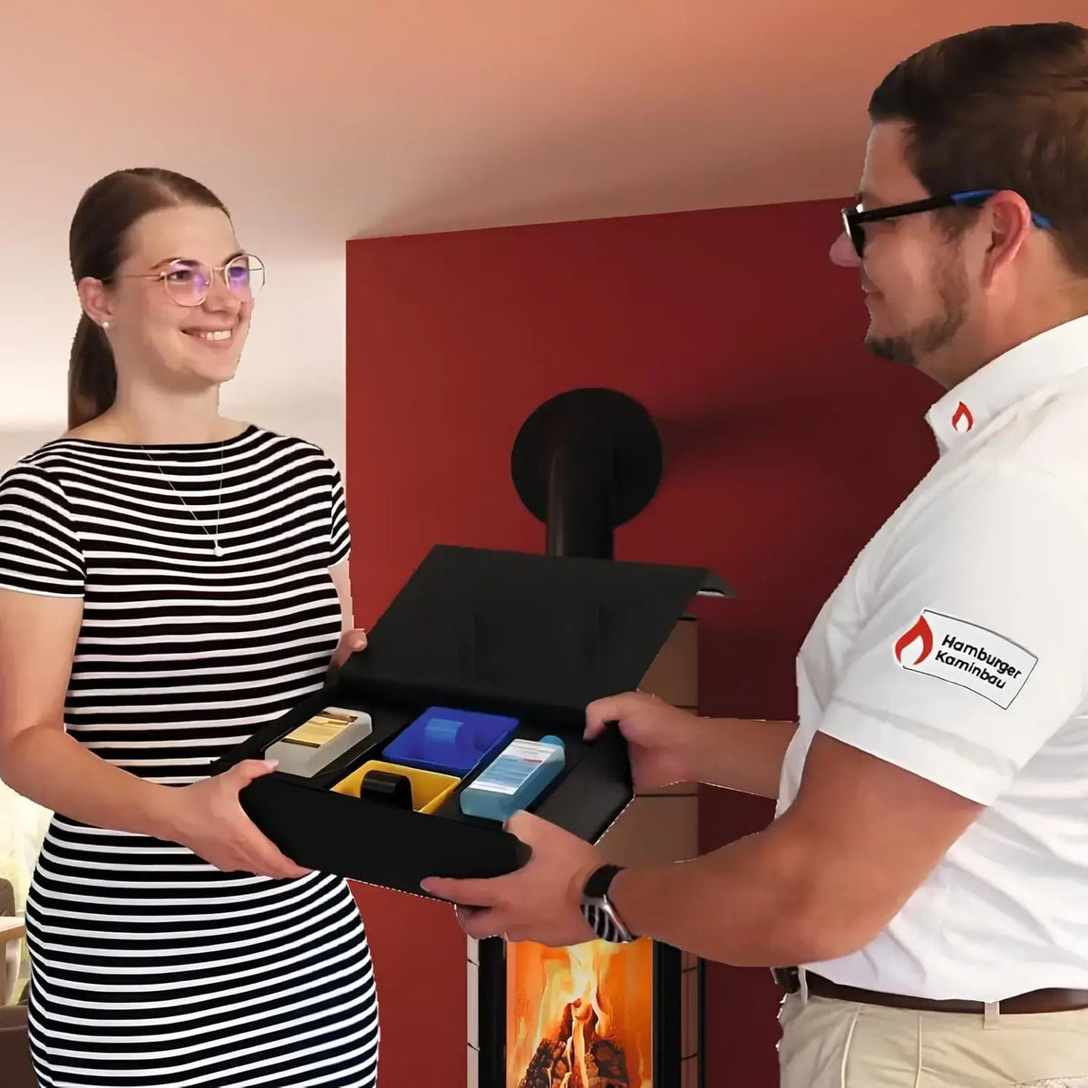 Kaminscheiben Präsent-BOX kompakt – Zwei Personen bei der Übergabe der geöffneten Geschenkbox