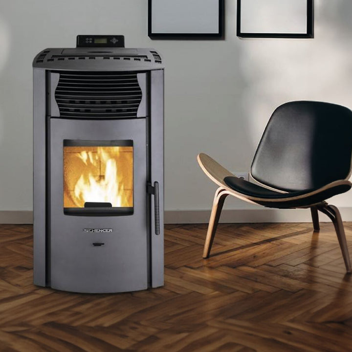 Pelletofen SCHENGER HP51 | 8,8 kW – Dunkler Pelletofen mit Feuer neben einem Sessel