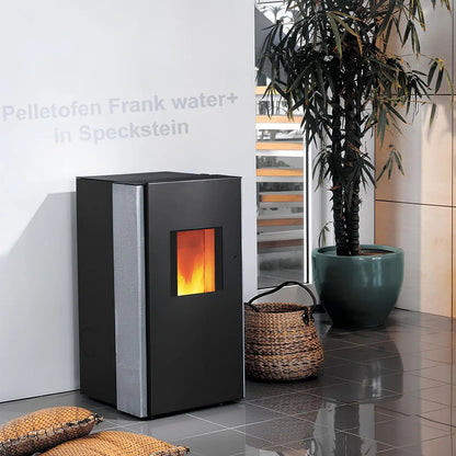 Pelletofen Wodtke Frank water+ | 8/10 kW | wasserführend – Pelletofen mit Steinverkleidung im Wohnraum neben einer Pflanze