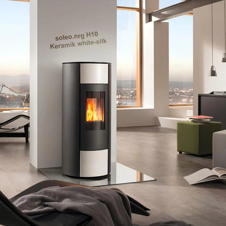 Pelletofen Wodtke soleo.nrg H10 air+ | 6/8 kW – Pelletofen mit heller Keramikverkleidung und Feuer im Wohnraum